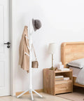 Wooden Coat Rack Stand With Eight Hooks Freestanding Coat Tree With Three Adjustable Heights in a bedroom with a hat and coat.