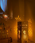 Cozy 13.5 Inch Pineapple Lantern Wooden Farmhouse Decor glowing warmly indoors, showcasing pineapple motif and coastal style ambiance.