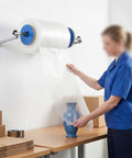 Slick Wall Mount Bubble Wrap Dispenser With Heavy Duty Galvanized Steel and Smooth Tidy Rewind Ready Packs Shipping Fits Air Cushion Film Rolls Up To Forty Inches Wide in use, wrapping a vase.