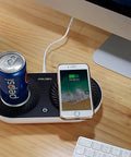 Slick Coffee Mug Warmer And Drink Cooler With Quick Wireless Charger 3 In 1 Electric Cup Heating Base on a wooden desk with a soda can and smartphone.