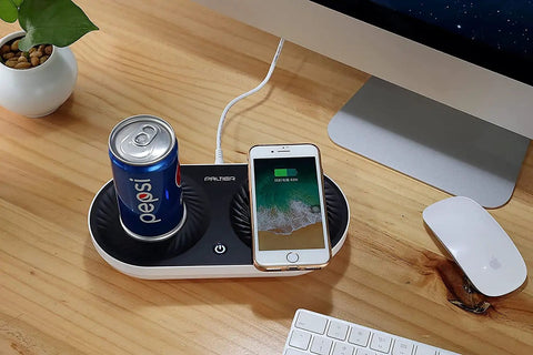Slick Coffee Mug Warmer And Drink Cooler With Quick Wireless Charger 3 In 1 Electric Cup Heating Base on a wooden desk with a soda can and smartphone.