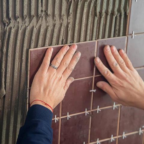 1/16-inch plastic cross tile spacers installed between brown ceramic wall tiles
