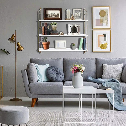 Living room with dope floating shelves, gold wall shelf for bathroom and kitchen, sleek minimalist vibe above gray couch.