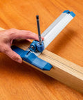 Hand using 9 Inch Quick Draw Marking Gauge For One Hand Operation With Spring Loaded Pencil Carriage And Dovetail Keyway on wood plank.