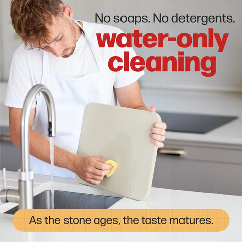 Person cleaning Rectangular Pizza Stone For Oven And Grill With Free Wooden Peel, Extra Large 15 By 12 Inch Cordierite Stone under water