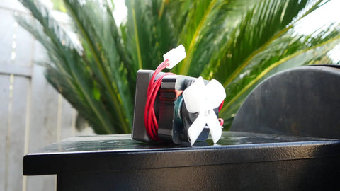 Upgraded Heavy Duty Auger Motor For Pellet Grills Plug And Play Quick Install With Shear Pin And Nut Includes One Year Warranty Silver Finish No Sweat Operation Totally Reliable motor with red wires and white fan on a dark surface.