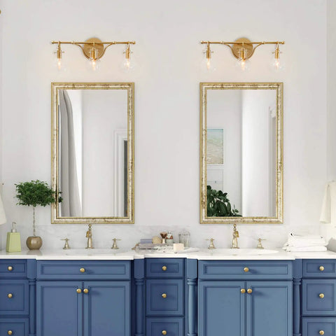 Bathroom with two Brushed Gold Vanity Light Fixture With Three Clear Glass Globes Over Mirror, blue cabinets, dual mirrors.