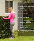 Woman installing Expandable Artificial Ivy Privacy Screen For Patio Balcony Garden And Backyard Outdoor Privacy Panels