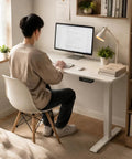 Compact Electric Standing Desk With Single Motor And One Touch Lift System Lowkey Perfect For Small Home Offices in use with monitor.