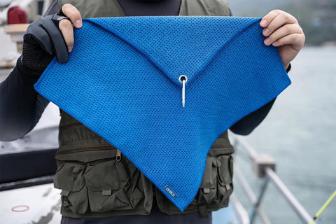 Person holding blue microfiber towel with waffle pattern, Grab And Go Clip On Microfiber Fishing Towels With Waffle Pattern, Quick Dry.