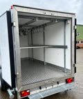 Inside view of a Sleek Portable Refrigerated Trailer Featuring Heavy Duty Mobile Cooling System For Catering Teams And Large Outdoor Events Keeps Everything Slick And Chilled On The Go, showcasing shelves and hooks.