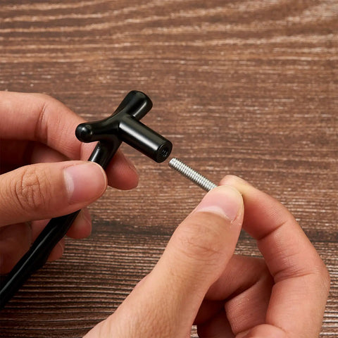 Black T-bar handle from 24 PC Resin Tray Handle Set For DIY Cabinets And Drawers with screw on wooden surface