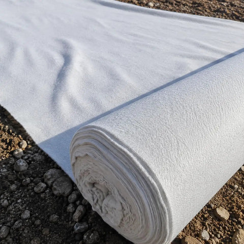 Heavy Duty Polyester Ground Cover Mat With Built Like A Tank Weed Barrier And Water Permeable Drainage Design For Outdoor Landscaping Playground Surface Base Foundation Underlayment in rolled position on soil.