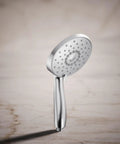 Forte Multifunction Handheld Shower Head With Three Spray Settings, polished chrome finish on marble background