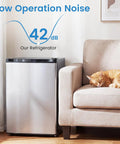 Compact 2.1 Cu Ft Upright Freezer With Reversible Door And Adjustable Thermostat For Dorms And Apartments Smooth Operator Design With Slide Out Shelves In Clean Silver For Plug And Play Frozen Storage next to a sleeping cat.
