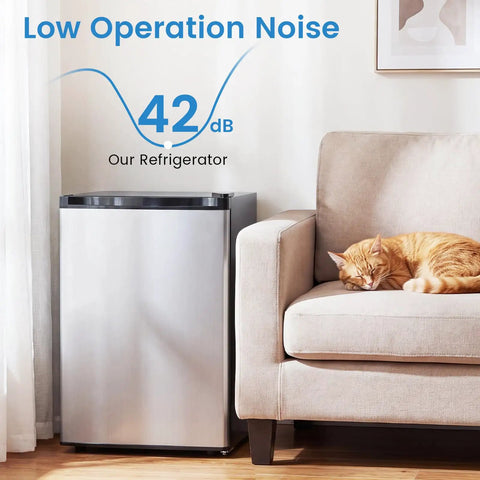 Compact 2.1 Cu Ft Upright Freezer With Reversible Door And Adjustable Thermostat For Dorms And Apartments Smooth Operator Design With Slide Out Shelves In Clean Silver For Plug And Play Frozen Storage next to a sleeping cat.