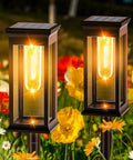 Outdoor Solar Pathway Lights Six Pack Waterproof LED Filament Lamps for Garden Walkways with warm glow in a flower garden