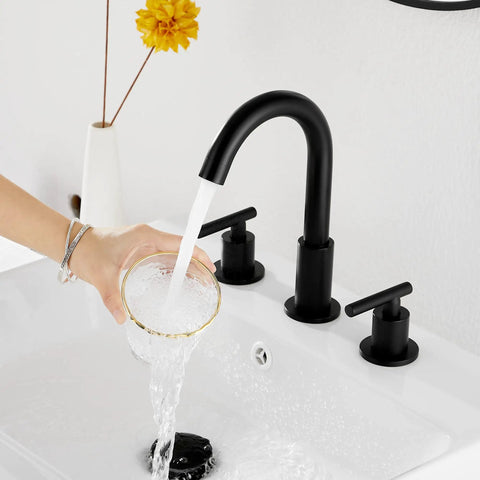 Person filling a glass under Black Bathroom Faucet With Two Handles Widespread 3 Holes Deck Mount No Fuss Install 360 Degree Swivel Spout Pop Up Drain 8 Inch Center 1.19 GPM Flow Cold And Hot Water Mixing Sleek Modern Sink Fixture