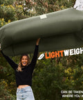 Person holding Inflatable Lounger Couch Portable Air Sofa Chair For Camping Beach Hiking Lawn Backyard And Outdoor Festivals Pump Free