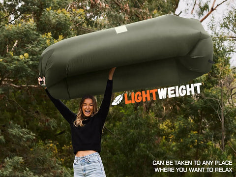 Person holding Inflatable Lounger Couch Portable Air Sofa Chair For Camping Beach Hiking Lawn Backyard And Outdoor Festivals Pump Free
