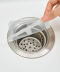 10 Piece Pack Disposable Shower Drain Catcher 3.9 Inch Silver Mesh Filter placed over a sink drain to catch hair and debris.