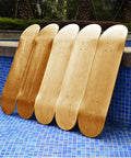 Blank Maple Skateboard Decks Set Of 3, 31 X 8 Inches, resting by a blue tiled poolside, showcasing their double tail design.