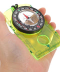 Hand holding Orienteering Compass With Scale For Camping And Hiking Navigation Go To Survival Gear Learning Tool For Direction
