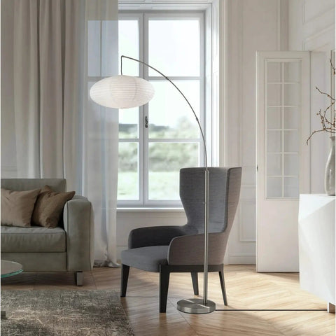 Corinne Arc Floor Lamp With White Paper Shade, Brushed Steel Finish in modern living room beside armchair, 80 inch height