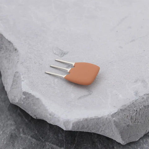 Single unit from 20 Pack Ten Point Seven Megahertz Ceramic Filter Crystal Oscillators For RF And IF Circuits on stone surface.