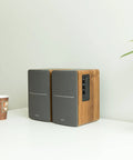 R1280T Powered Bookshelf Speakers With 2 Channel Near Field Studio Monitor Sound Wooden Enclosure on a desk