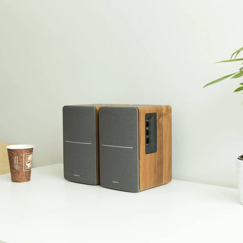 R1280T Powered Bookshelf Speakers With 2 Channel Near Field Studio Monitor Sound Wooden Enclosure on a desk