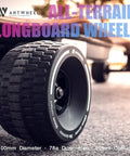 Close-up of all-terrain longboard wheels 100mm 65mm urethane 78A high rebound, attached to an electric skateboard on pavement.
