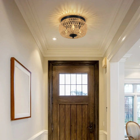 Three Light Woven Rattan Flush Mount Ceiling Light Fixture With Handwoven Cage Shade casting shadows in a foyer
