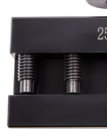 Black metal lathe tool post holder with two threaded posts and springs.