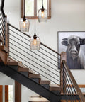 Three Light Teardrop Glass Pendant Chandelier With Hand Blown Seeded Bubbles hanging above a modern rustic staircase