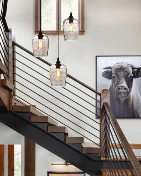 Three Light Teardrop Glass Pendant Chandelier With Hand Blown Seeded Bubbles hanging above a modern rustic staircase