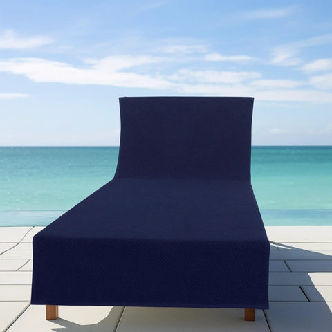 Two Pack Navy Blue Pool Lounge Chair Covers With Waffle Weave Cotton Terry Towels displayed at the beach.