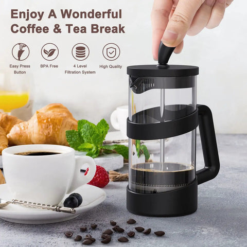Hand pressing handle of compact 12 oz mini French press coffee maker for camping and travel on breakfast table setting