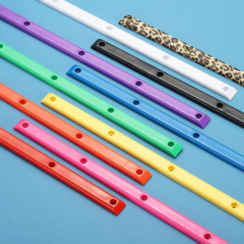 Various colored Rib Bones Rails For Skateboards displayed on blue surface, including purple ABS plastic for smoother rides.