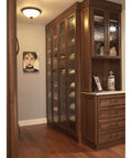 Aspen Round Cabinet Knob In Light Bronze Finish, installed on tall wooden cabinets with decorative glass doors in elegant room.