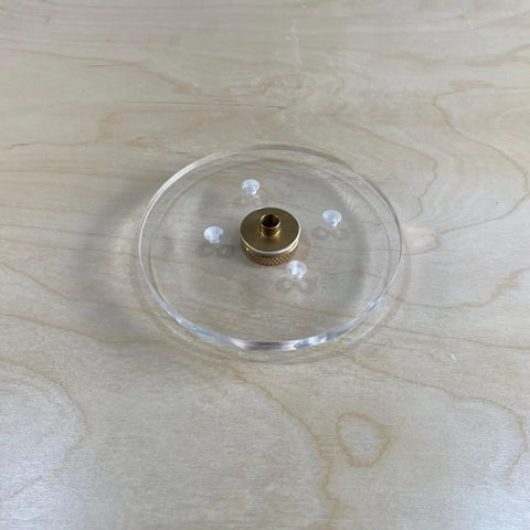 Close up of a six inch round clear acrylic router base plate with pre drilled holes for RT0701C or XTR01Z models.