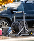 Woman using 200 Foot Heavy Duty Aluminum Upright Hose Reel With Rust Proof Frame Leak Proof Brass Connections to wash car