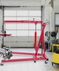 Heavy Duty Folding Hydraulic Engine Hoist Stand Built With Hella Tough Carbon Steel, lifting an engine in a garage.