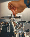 Hand adjusting the flow valve on the Alto Dual Boiler Espresso Machine With PID Control And Flow Adjustment For Top Shelf Precision Shots.