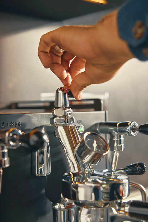 Hand adjusting the flow valve on the Alto Dual Boiler Espresso Machine With PID Control And Flow Adjustment For Top Shelf Precision Shots.