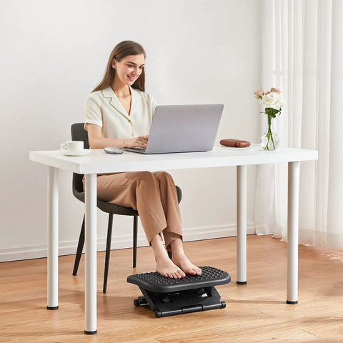 Woman using Adjustable Ergonomic Desk Footrest with Massage under a white desk, promoting posture and leg comfort in home office