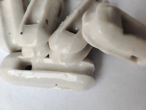 Close-up of glazed ceramic antenna insulators in a 22 pack, showing small ceramic isolators for dipole and other antenna setups.