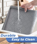 Person washing an Under Sink Waterproof Silicone Cabinet Mat 34 Inch by 22 Inch, Thick Edge Protector for Kitchen and Bathroom in a sink.