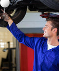 Mechanic using Telescoping Circular Inspection Mirror With Flexible Shaft 360 Degree Rotation Round Mirror Extended Handle 4 Inch Diameter on vehicle undercarriage in garage