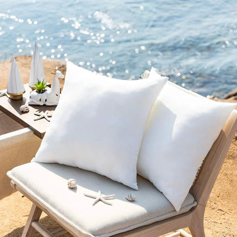 Premium Outdoor Pillow Inserts Pack Of 2 Square 18 By 18 Inches Water Resistant Polyester Throw Pillows on a chair outdoors